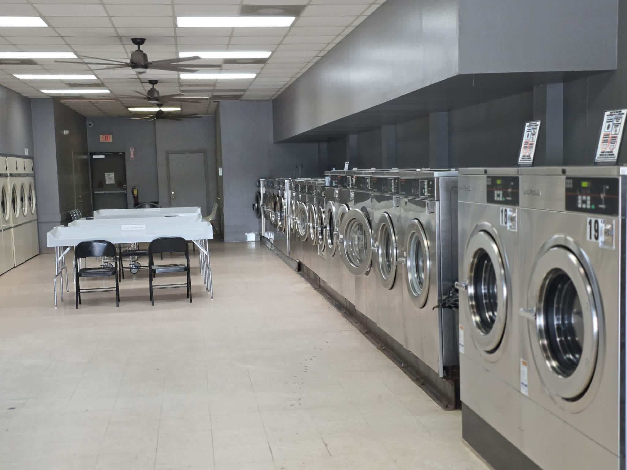 Row of washing machines in a bright, modern laundromat